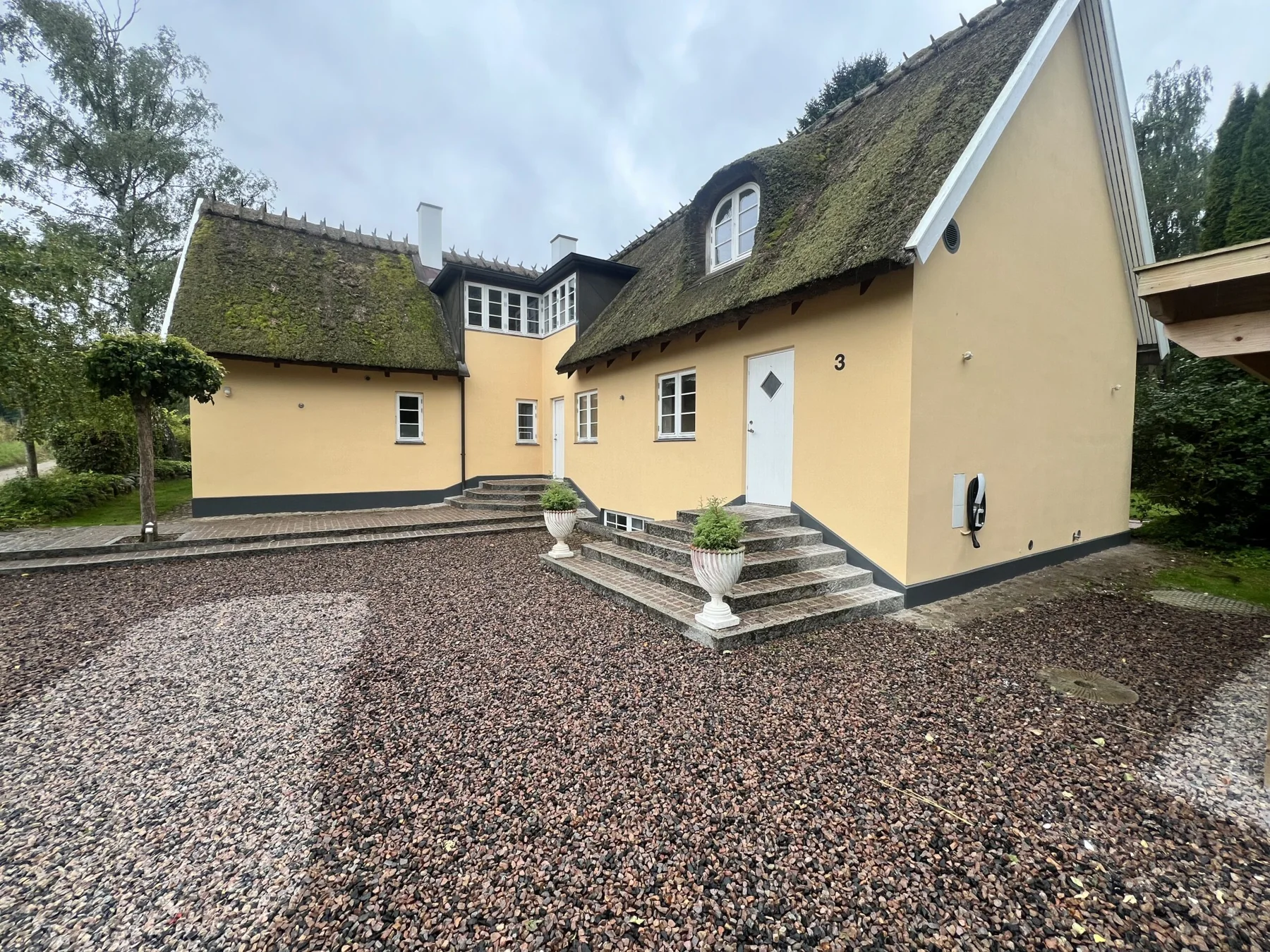 Gul facade og indgangstrappe på et hus fra PSK’s portfolio